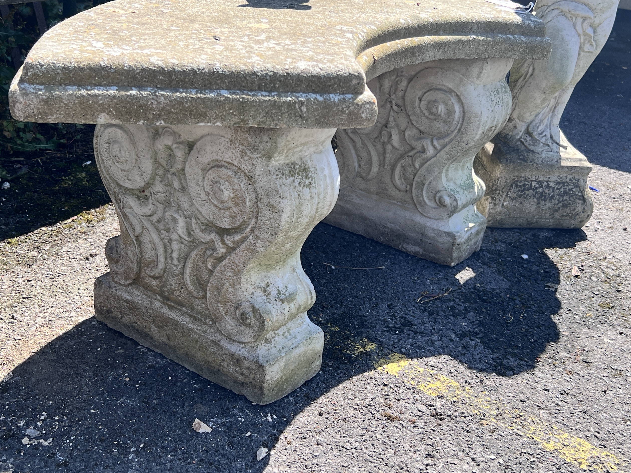 A small reconstituted stone curved garden bench, width 110cm, height 44cm, together with a stone pedestal and a small dog ornament